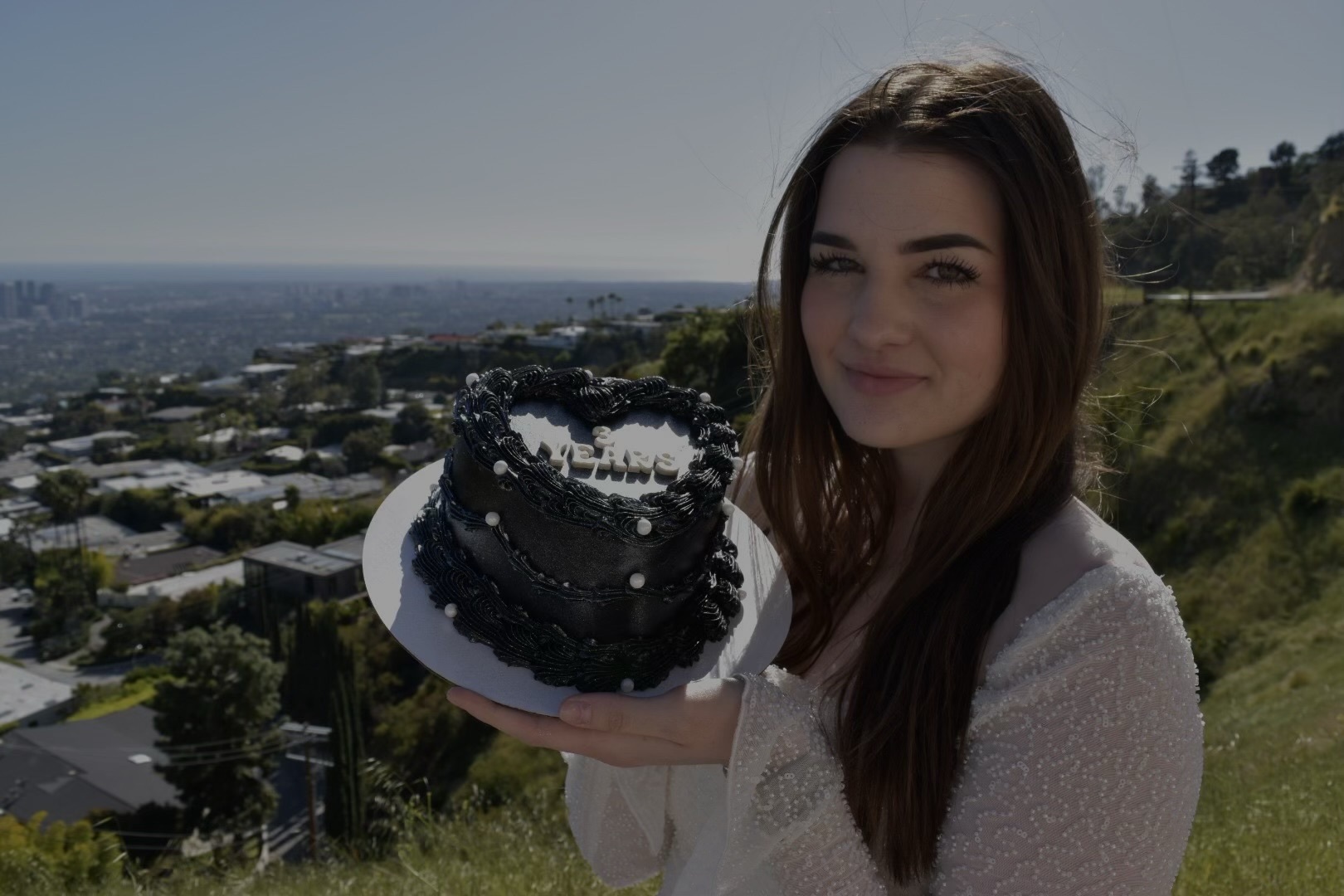 Sara holding a cake to celebrate the third anniversary of Etched and Elegant