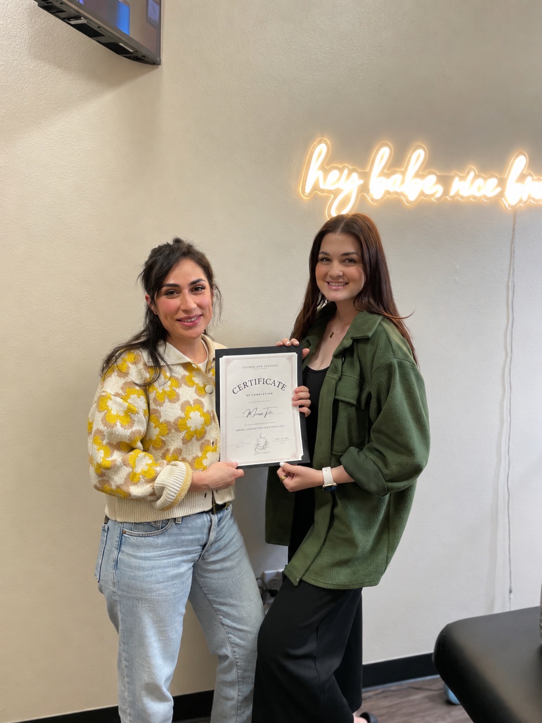 Sara in a green jacket with a brow shaping student
